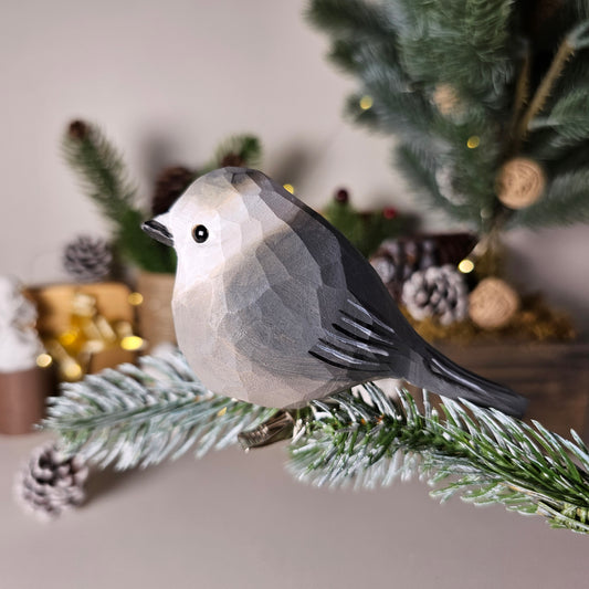 Hand-carved solid basswood Canada Jay clip-on ornament showing soft grey-and-white plumage, dark nape patch, and rounded boreal silhouette — by Painted Bird Shop.