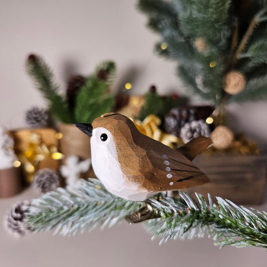 Hand-carved solid basswood Goldcrest clip-on ornament perched on a pine branch, showing golden crown stripe and olive-green hand-painted plumage detail