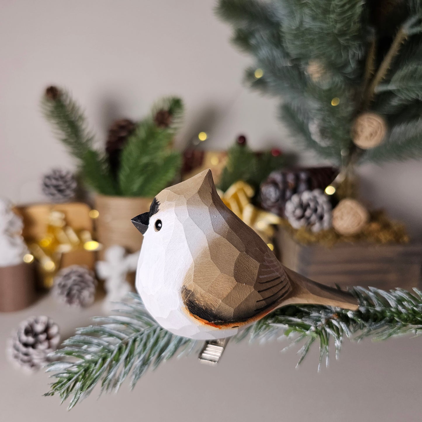 A clip-on ornament depicting a tufted titmouse bird perched on a branch, with a holiday decor background.