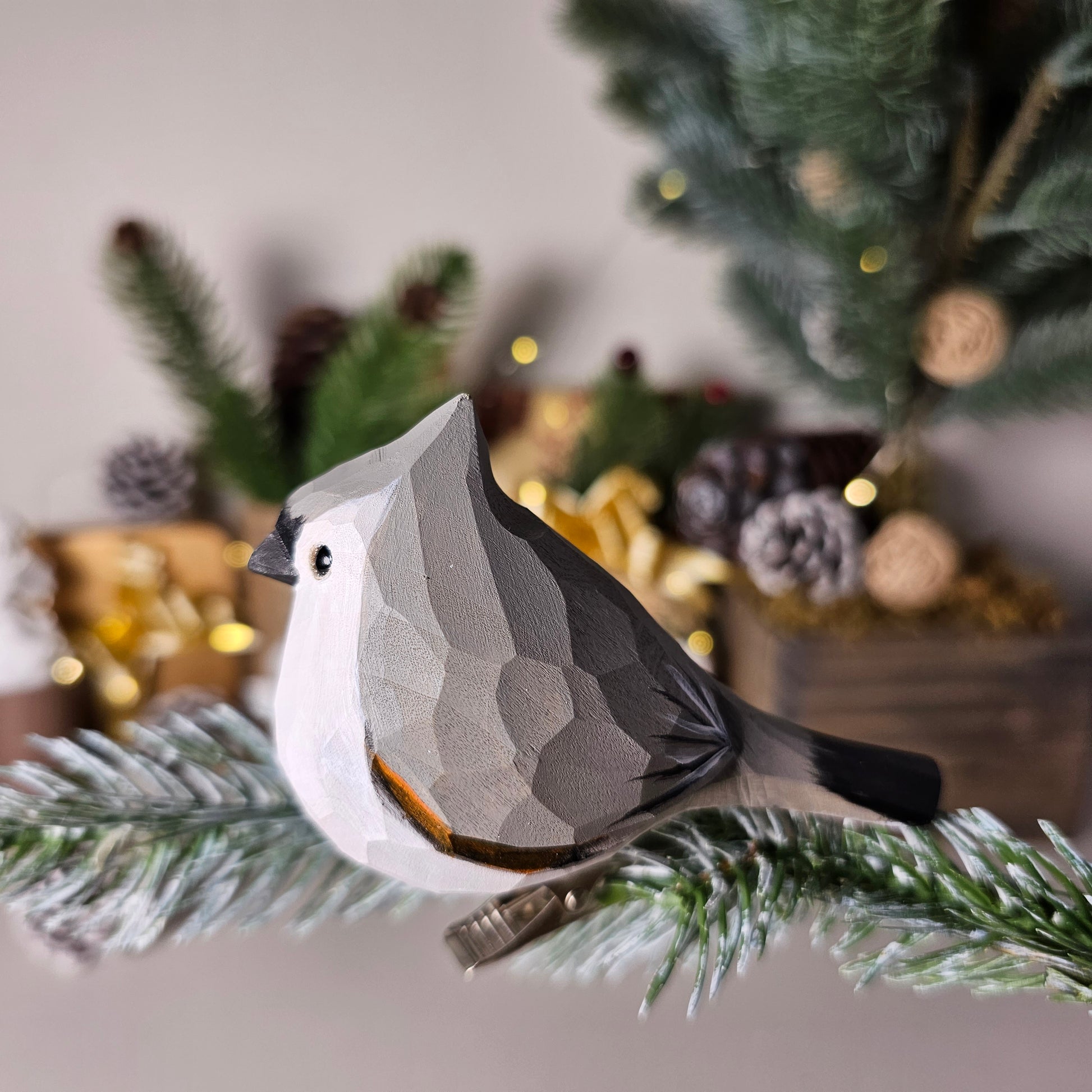 Hand-carved solid basswood Tufted Titmouse clip-on bird ornament in gray, showing upswept crest and hand-painted feather detail, clipped to a pine branch