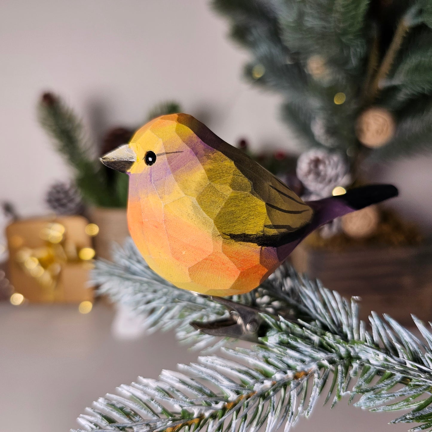 Hand-carved solid basswood White-Browed Tit-Warbler clip-on bird ornament showing violet-blue plumage and white supercilium detail, perched on a natural branch
